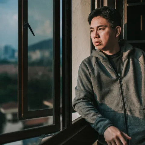 A man looking outside from his window