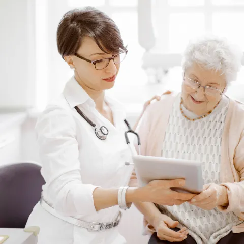 An elderly woman talks to her doctor