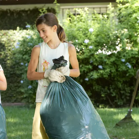 A family cleans up the lawn together.