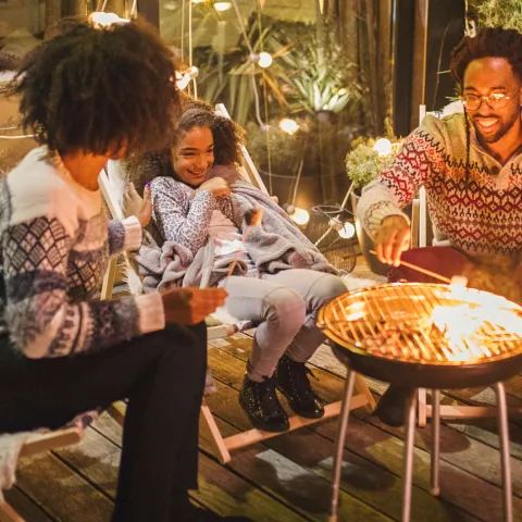 A family roasting marshmallows outside.