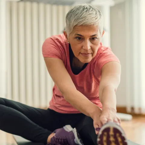 Older woman stretching to go for a run.