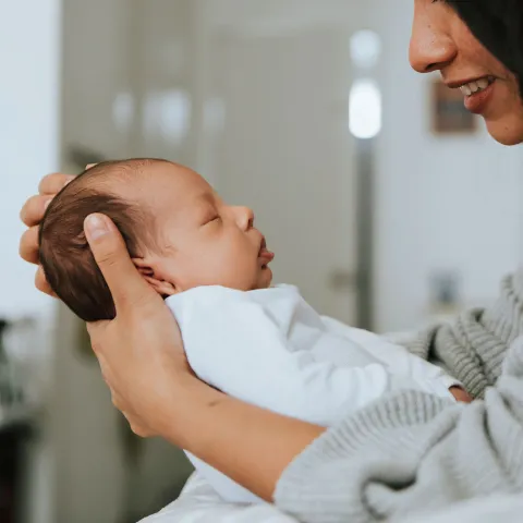 A mom holds her newborn infant. 