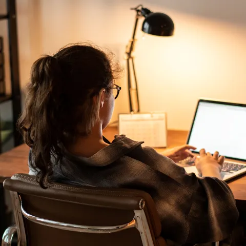 A teenager does her homework on her laptop at home