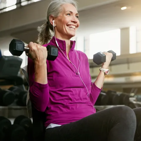 A woman lifting weights in the gym.