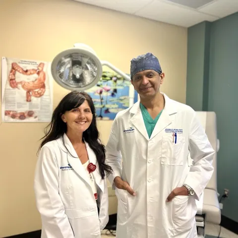 Tina Ellison smiling on the left of Dr. Abubaker Ali smiling on the right.