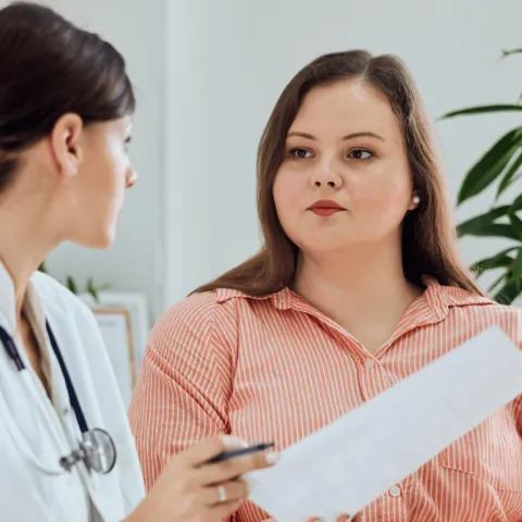 A woman discusses medical treatments with her doctor.