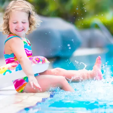 Little girl splashing around in a swimming pool