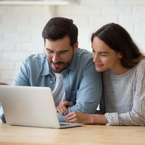 Couple looking at laptop and smiling