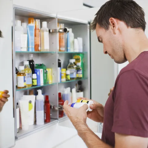 Man cleaning medicine cabinet
