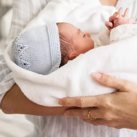 baby in adult's arms