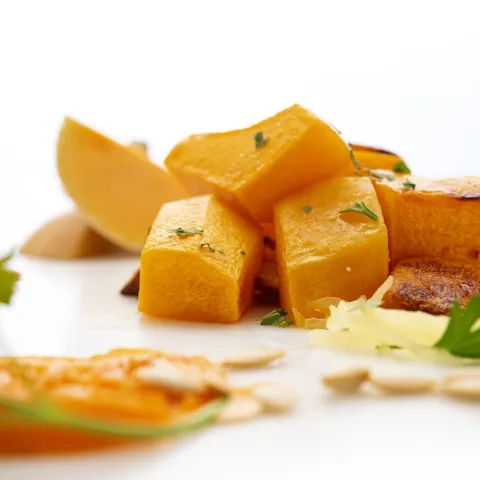 Seven chunks of butternut squash with parsley garnish
