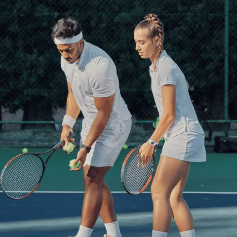 A man and woman playing tennis.