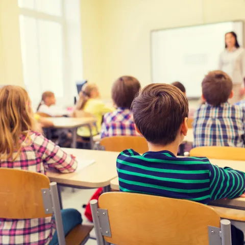 Children sitting in chairs in their classroom.