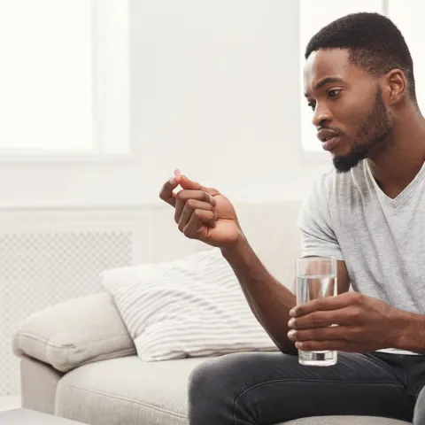 Man taking medicine with water
