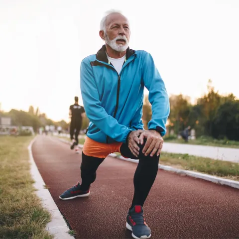An older man stretching before a run.
