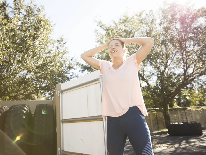 A young Caucasian woman catches her breath during outdoor exercise.