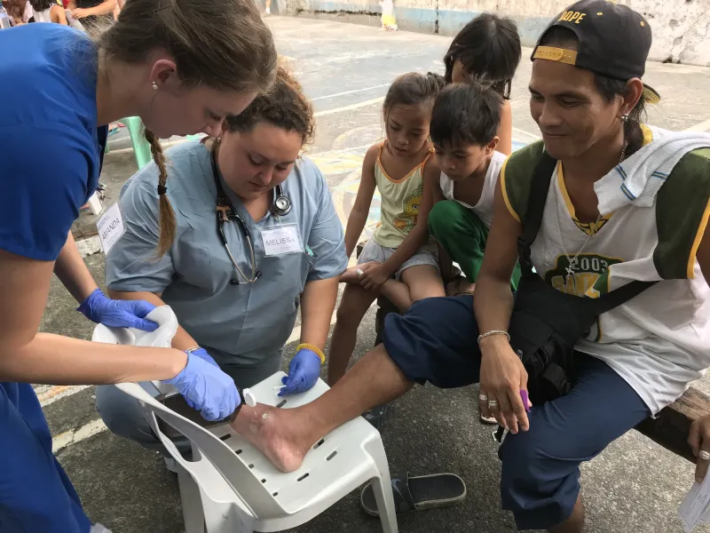 Volunteers with a patient in the Philippines