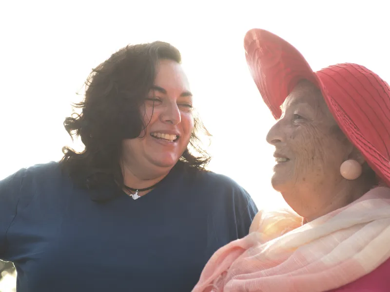 Two overweight women converse with each other.