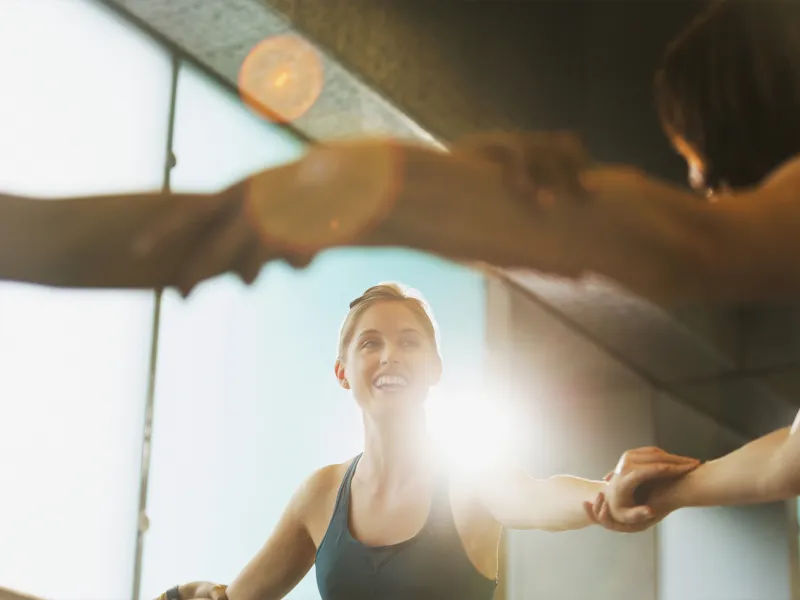A young Caucasian woman joins her peers in an exercise class.