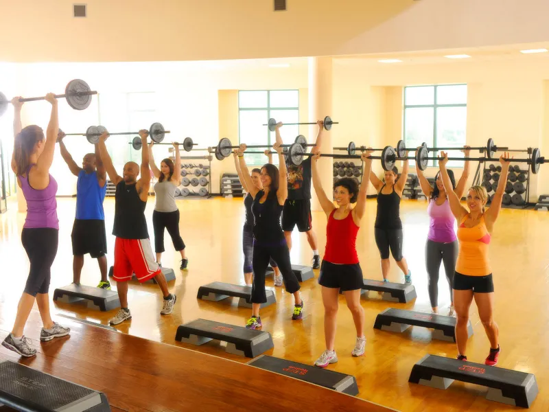 A group of people lighting weights at a fitness class. 