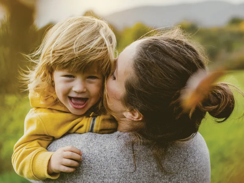 Mother holding smiling daughter