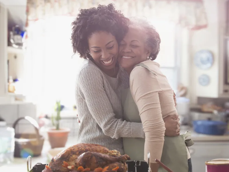 Mother and duaghter embracing in the kitchen filled with happiness