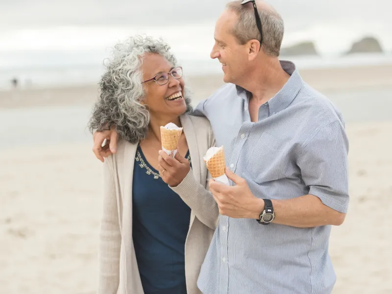 A couple enjoys a walk on the beach together.