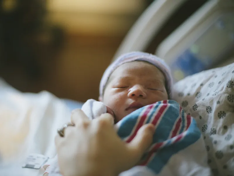 A mother holds her newborn baby in their AdventHealth hospital room