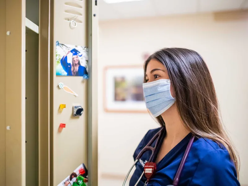 A nurse looking at a graduation photo of herself