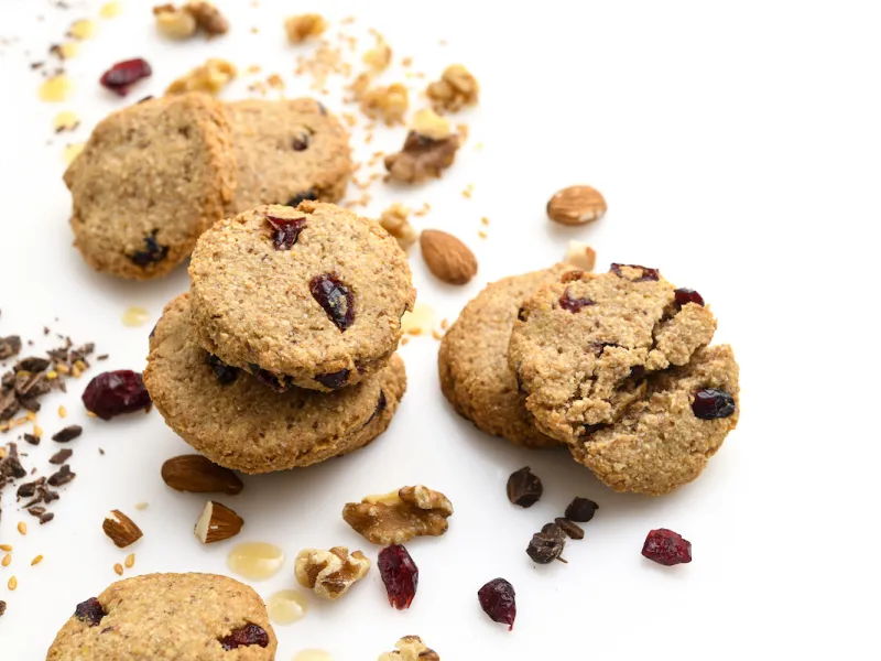 Six cranberry-walnut cookies amid almonds and craisins