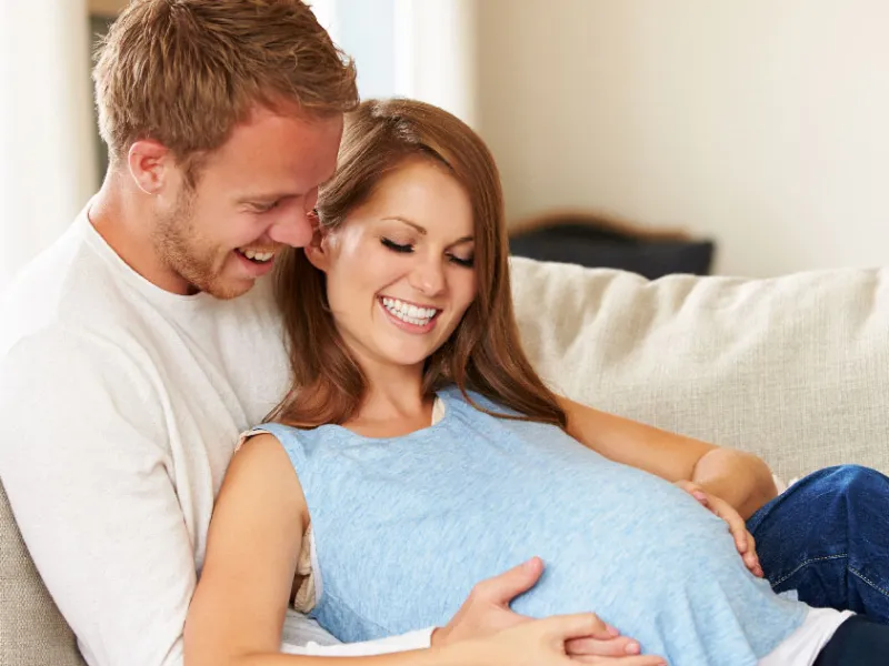A couple admiring the belly of their baby