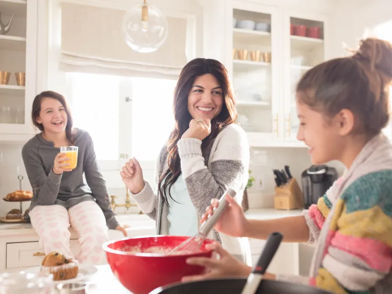 Mother baking with her daughters in the kitchen.
