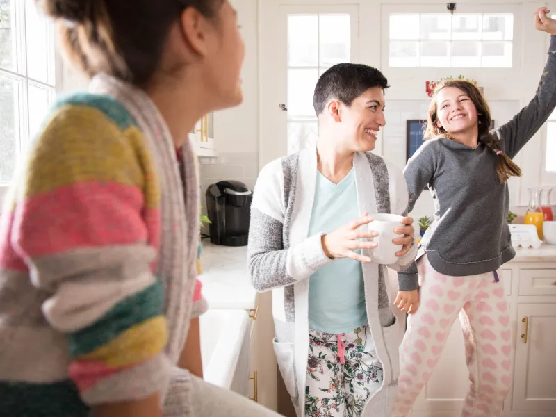 Family dancing in kitchen during breakfast.