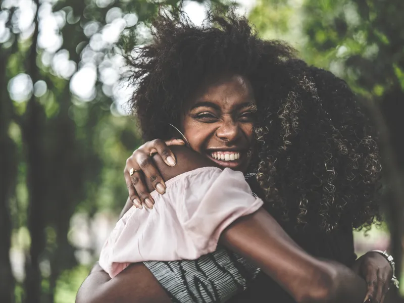 Two women hugging and smiling.