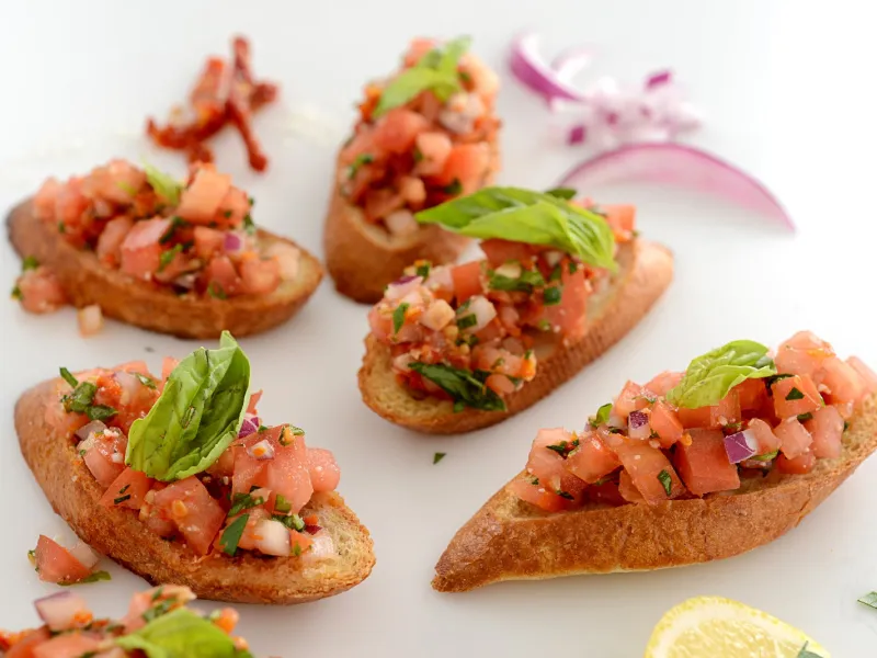 toasted slices of bread, topped with chopped tomato, garlic, onion and basil