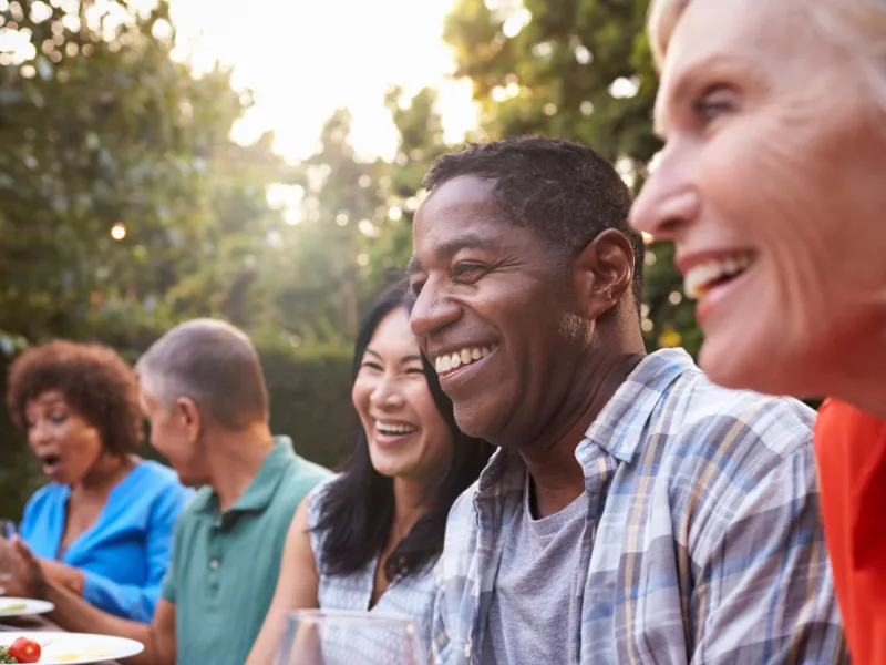 Friends sitting outdoors at a table during a dinner party.