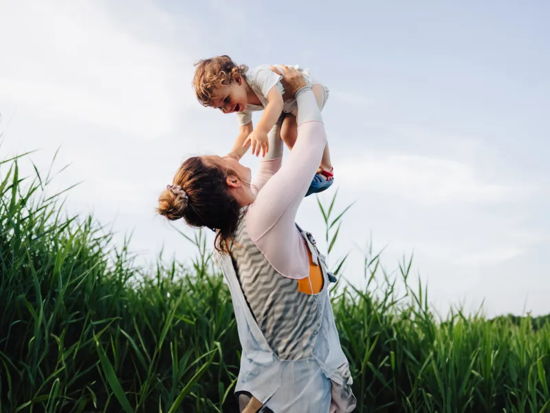 A Mother Holds Her Son to the Sky in a Corn Field