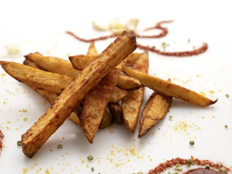 Small pile of French fries on a white counter.