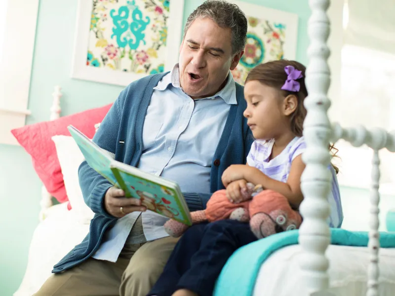 Grandfather reading a story to his grand daughter