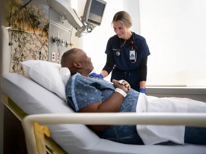 A Provider Speaks to a Patient in a Hospital Bed