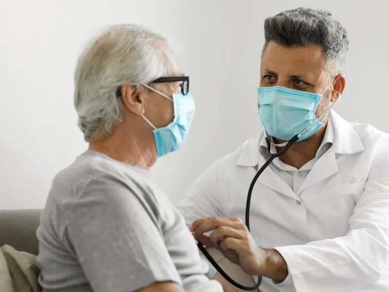 A doctor listening a patient's heart.