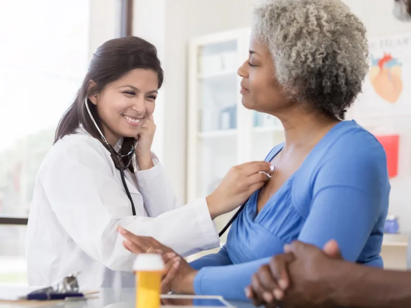 A doctor listens to a patient's lungs.