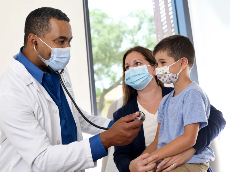 A doctor treating a mother and son.