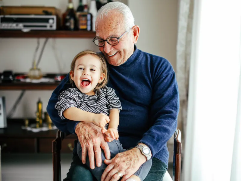 A grandfather holding his grandchild. 