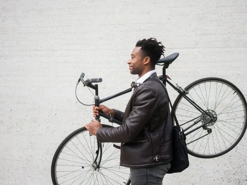 A man carries his bike after riding to work