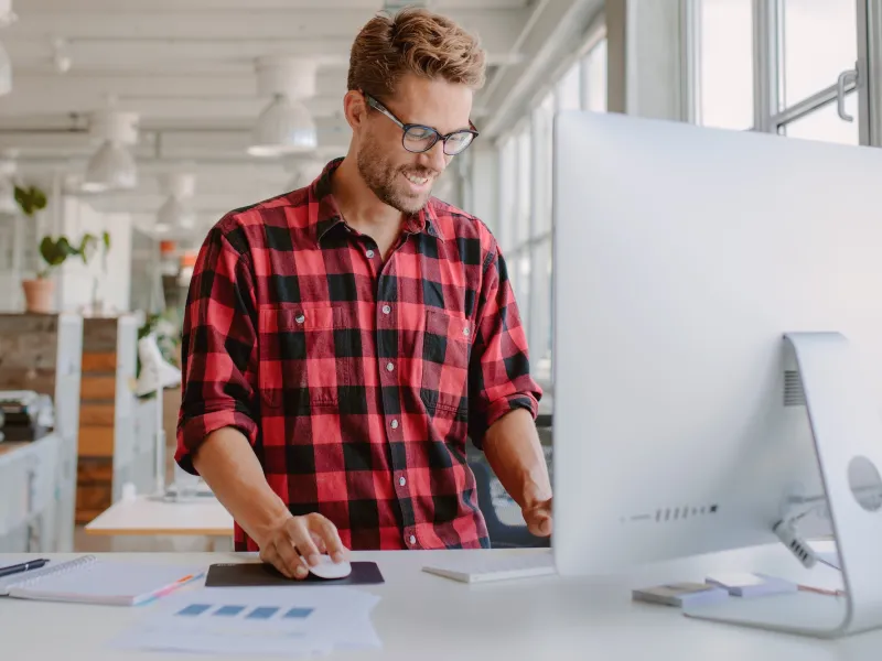 A man works at a standing desk.