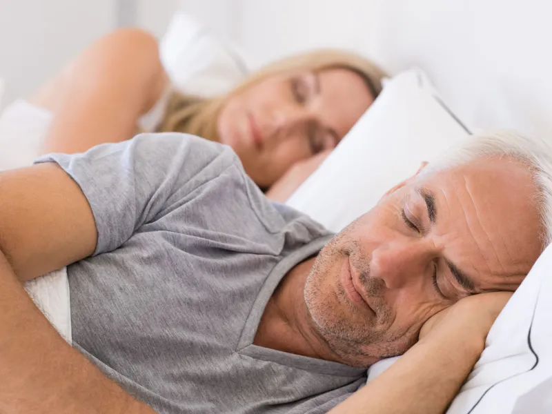 Mature couple sleeping on their bed