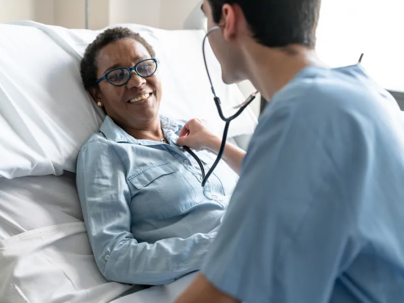A patient in a hospital bed has her heart checked.
