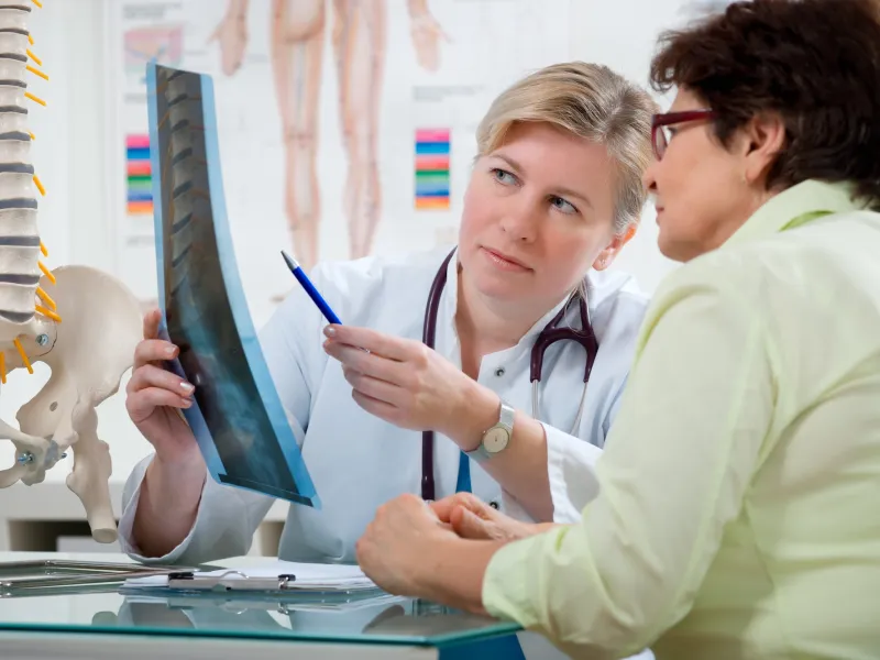 A woman looks at her back x-ray with her doctor