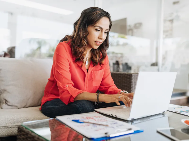 A woman on her laptop in her living room.